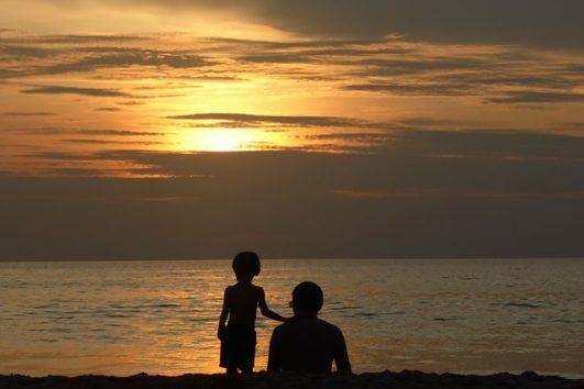 A father and his son enjoying the sunset from Radhanagar Beach