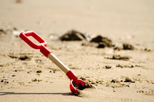 A shovel dug into the sand at Radhanagar Beach